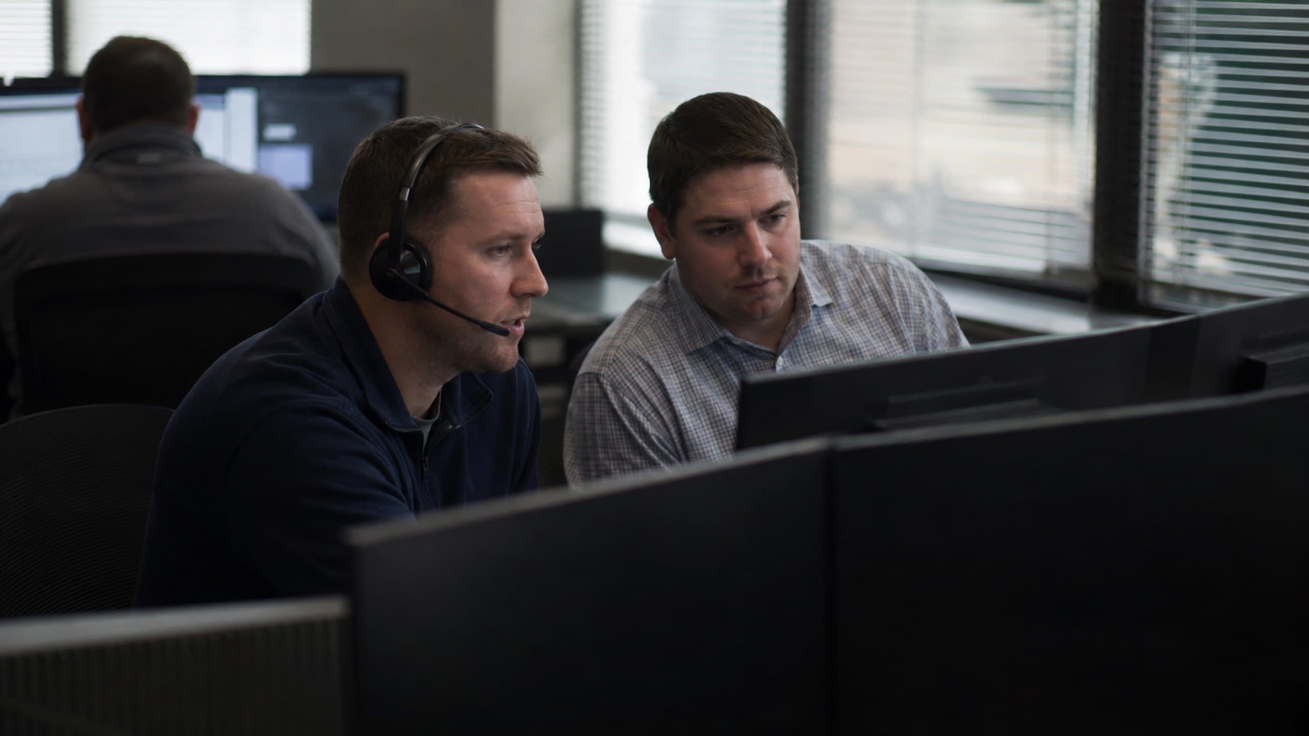 A sales team working at laptops around one table